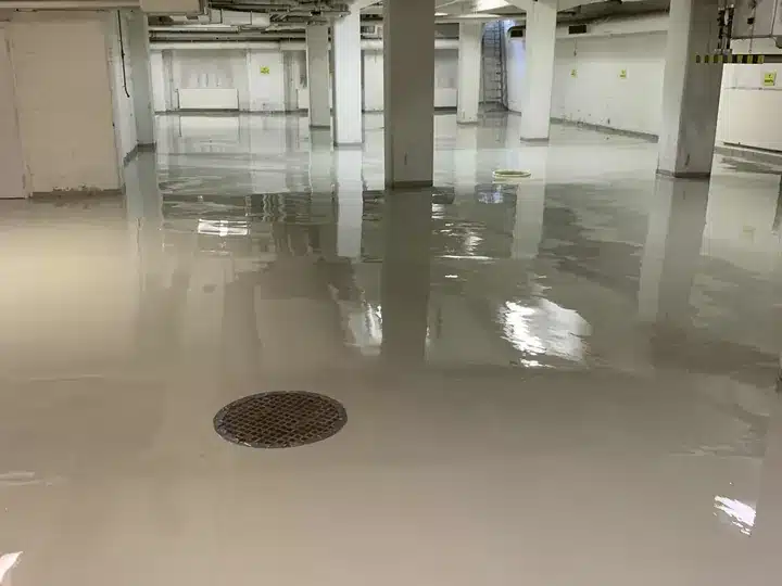 Vaalea epoksipinnoitettu lattia parkkihallissa